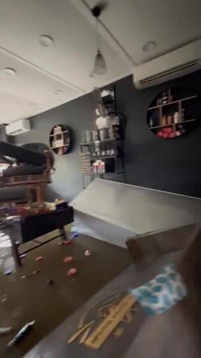 Hair Products Float in Floodwater at Inundated Barber Shop in Devastating Scenes
