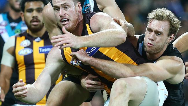 Intensity ... Jack Hombsh tackles Hawthorn forward Jarryd Roughead at Adelaide Oval. Picture: Sarah Reed