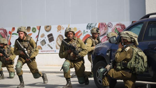 Israeli soldiers deploy in an area where civilians were killed in the southern city of Sderot, near the Gaza strip.