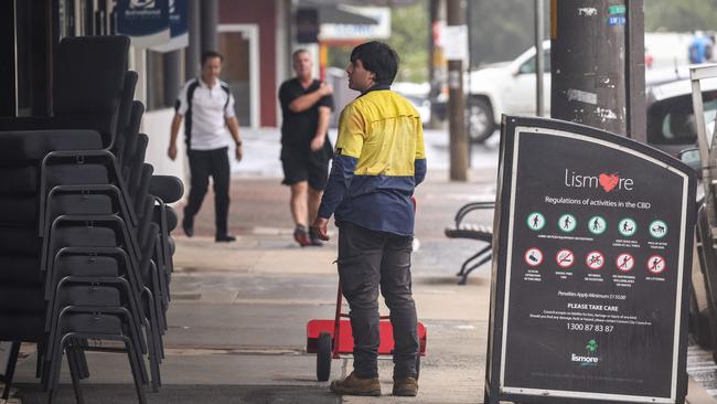 A worker pushes a trolley as he empties a shop in the town of Lismore on March 5, 2025. A rare tropical cyclone veered towards Australia's densely populated eastern coast on March 5, forcing scores of schools to close as worried residents stripped supermarket shelves bare. (Photo by DAVID GRAY / AFP)