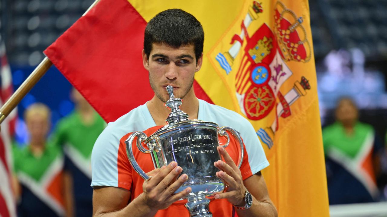 (FILES) In this file photo taken on September 12, 2022 Spain's Carlos Alcaraz celebrates with the trophy after winning against Norway's Casper Ruud during their 2022 US Open Tennis tournament men's singles final match at the USTA Billie Jean King National Tennis Center in New York. - Carlos Alcaraz wins the US Open and becomes the youngest ever world number one at 19. (Photo by ANGELA WEISS / AFP)