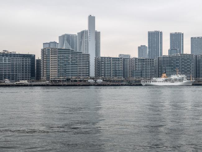 A ship sits moored next to the Tokyo athletes village. Many of the buildings were to be converted into luxury apartments, but that has all changed with the postponement of the Olympics.