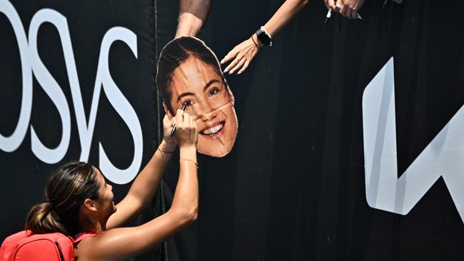 Britain's Emma Raducanu signs an image with her face for fans. Picture: AFP