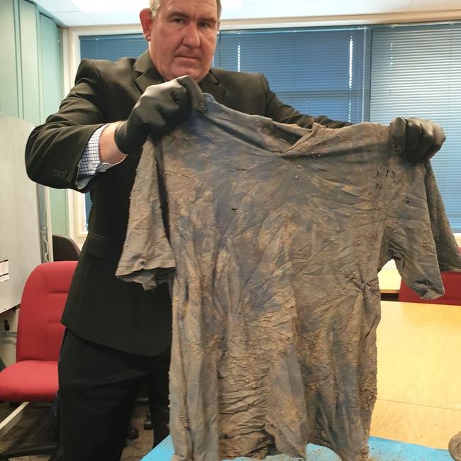 Clothes, shoes and a leg plate were found near the human remains off Keefton Road on the outskirts of Gympie. Gympie police Rob Lowry holds the shirt up.