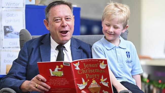 Year 3 student Harris reads with principal Tim Cleary at St Thomas Aquinas Primary School in Canberra. Picture: Martin Ollman