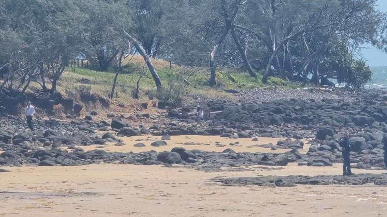 Police comb the beach at Bargara as part of their investigation after several containers of a suspicious substance washed up on Tuesday morning.