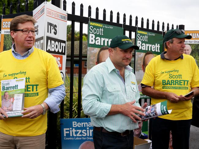 Nationals leader Troy Grant cuts a lonely figure amid a cavalcade of noisy anti-Nationals volunteers with Nationals candidate for Orange, Scott Barrett. Picture: Jonathan Ng