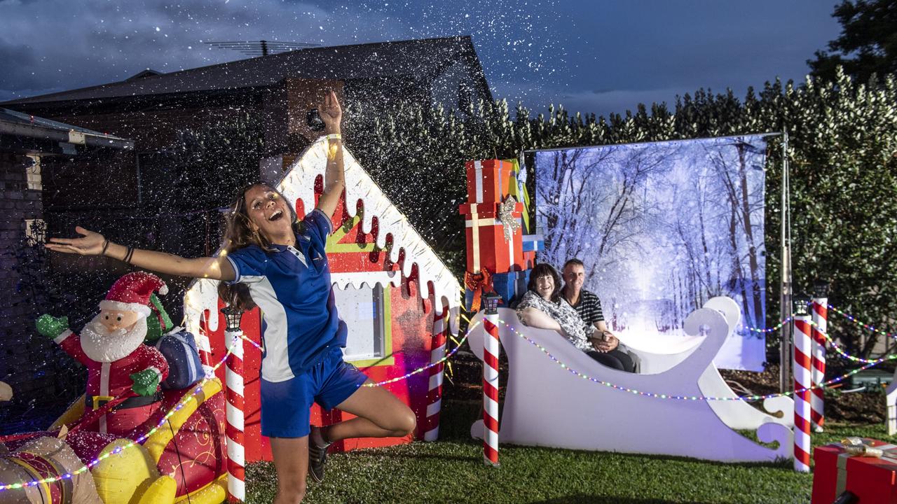 Sue and Pete Black with granddaughter Kira Suey in the foreground enjoying the snow machine. Christmas lights at 60 Gouldson Drive. Thursday, December 9, 2021. Picture: Nev Madsen.