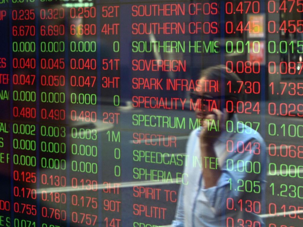 A pedestrian is reflected in the window of the Australian Securites Exchange in Sydney on March 13, 2020, as Australian stocks were down 7.3 percent in early trading. - Global stock markets suffered historic falls as panic spread on March 13 over the spiralling coronavirus crisis that has killed nearly 5,000 and infected sport, schools and society across the planet. (Photo by Saeed KHAN / AFP)