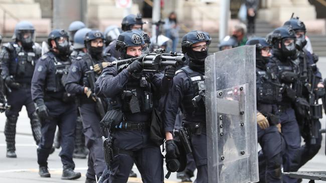 Riot police fire pepper capsules at protesters on Elizabeth Street on Wednesday. Picture: David Crosling