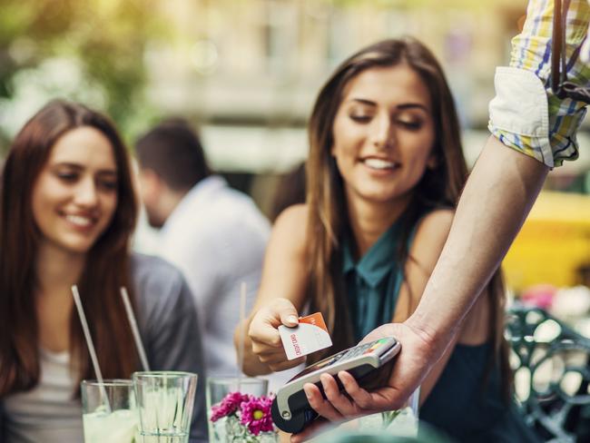 Young women having drinks in cafe making a payment with credit cardPicture: istock