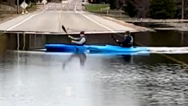 Kayakers cross flooded Minnesota road