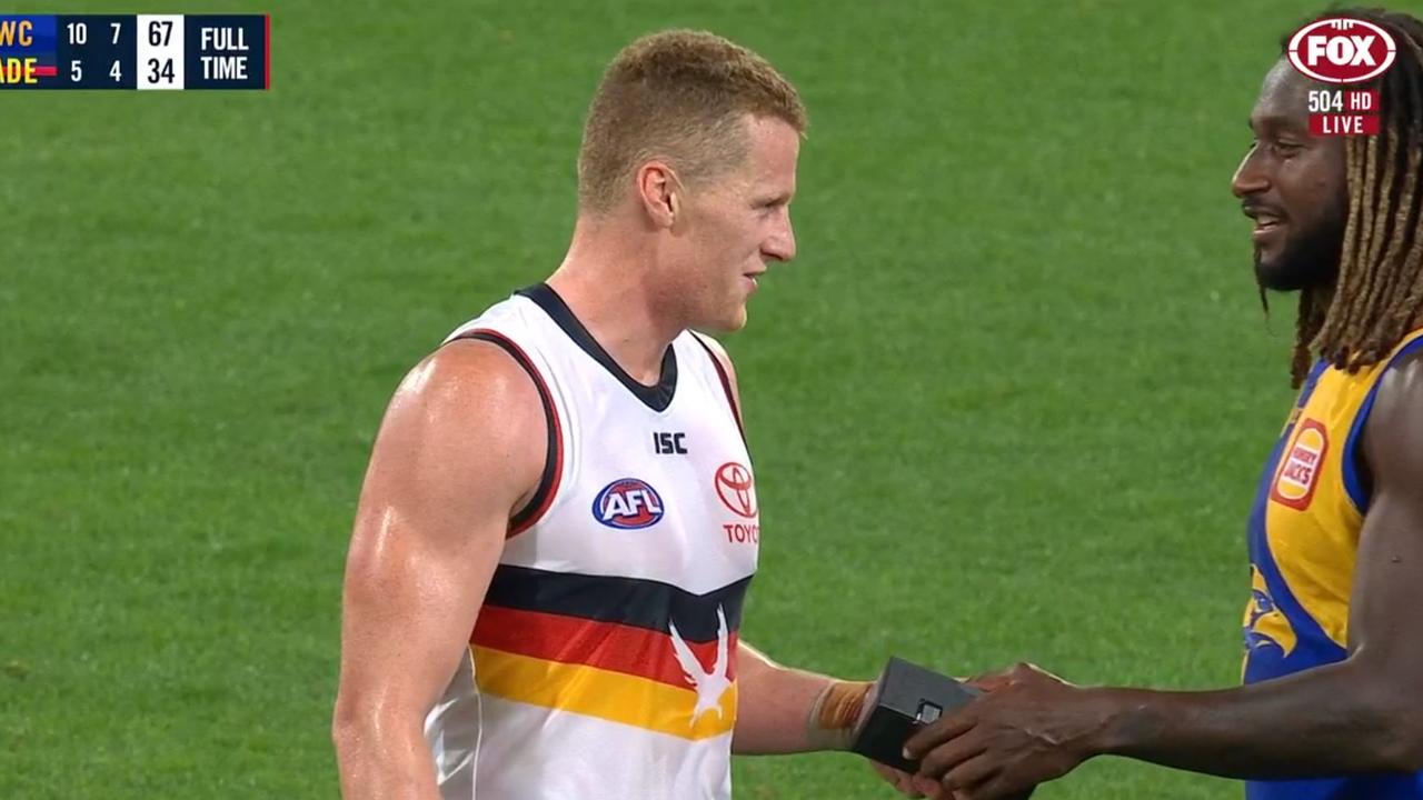 Nic Naitanui hands Reilly O'Brien a new phone after West Coast's game against Adelaide.
