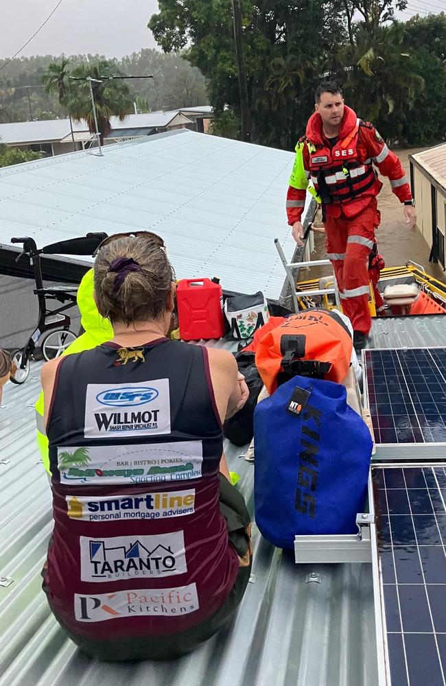 Stranded on their rooftop in Holloway’s Beach, a family waits for rescue after spending a day isolated on their kitchen island bench. Picture: Supplied