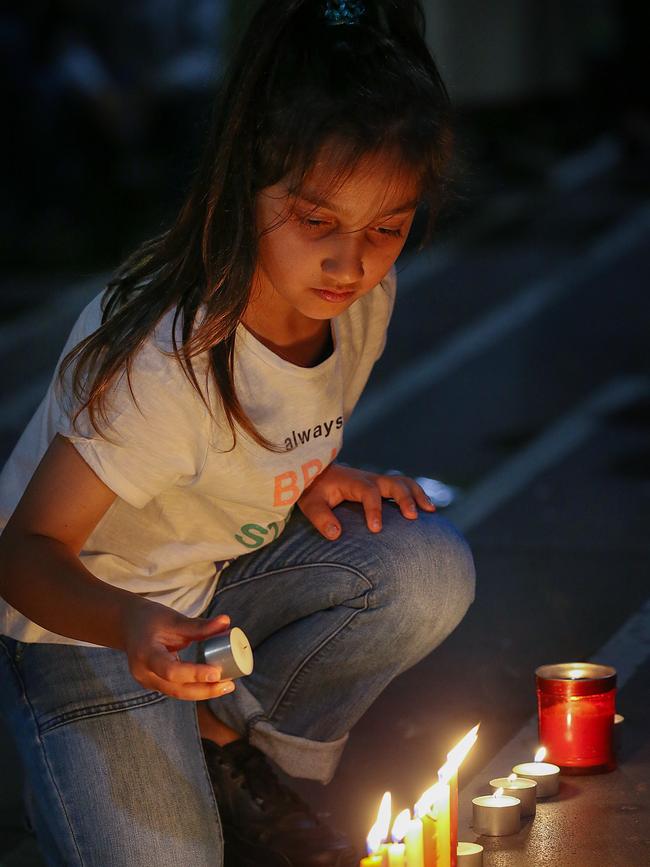 A young girl lights candles for the 49 people who were killed by the terrorist. Picture: Ian Currie