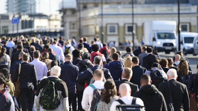 Large crowd of people commuting to work in London, England