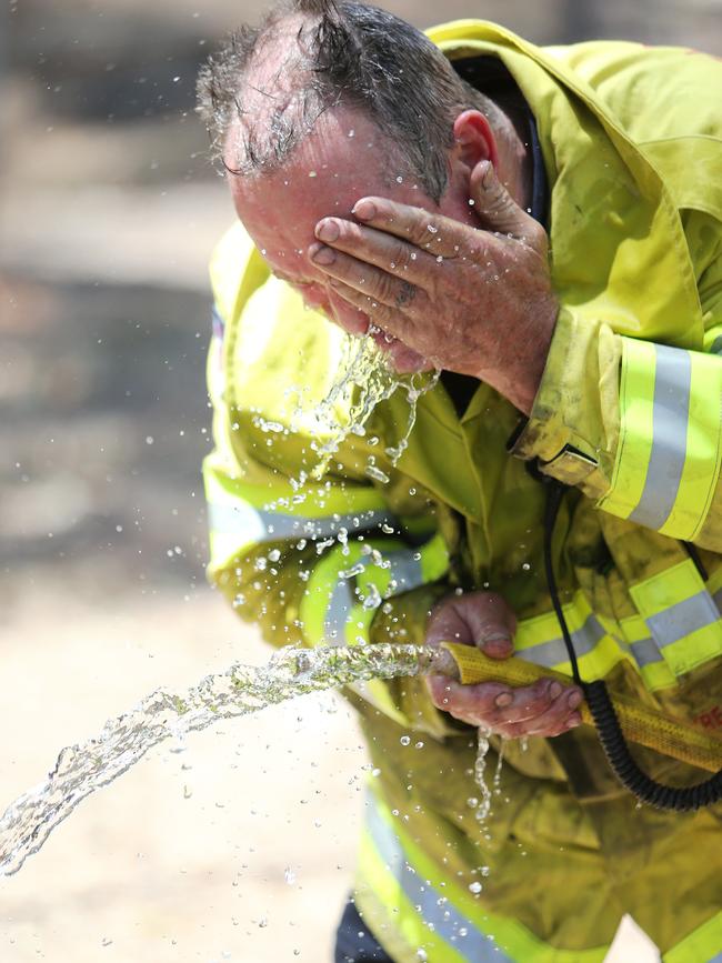 Wollongong firefighter Rod Watts cools down on the job at Tallwood Estate. Picture: Peter Lorimer