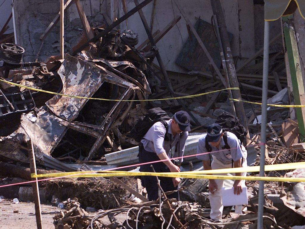 Police forensic officers searching through wreckage at the site of the Sari Club in Kuta in the days after the fatal blasts.