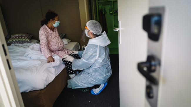 A doctor provides care to a patient in a hotel converted into a makeshift hospital for patients infected with coronavirus in Chelles, near Paris.