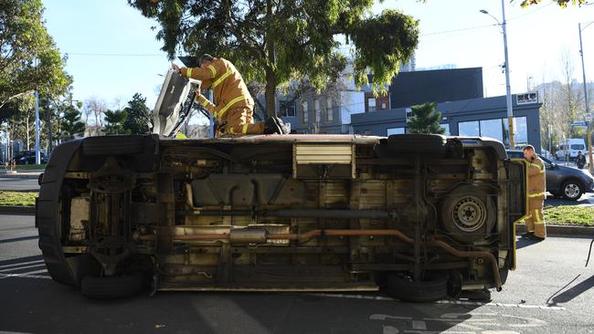 Metropolitan Firefighters attend to a Victorian Ambulance rollover on the corner of Queensbury and Peel street in North Melbourne, Thursday, June 21, 2018. (AAP Image/James Ross) NO ARCHIVING