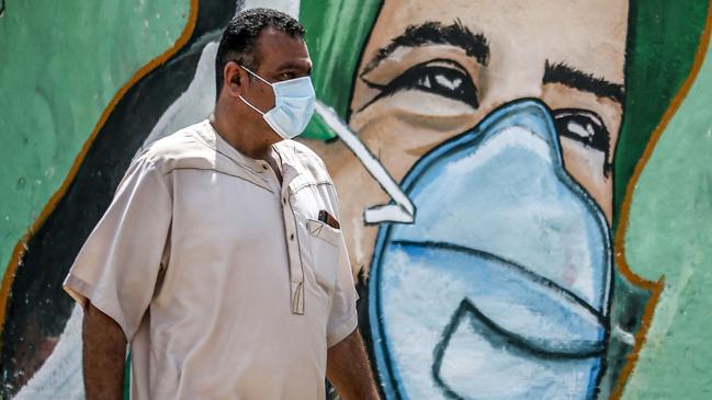 A mask-clad man walks past a mural in the southern Gaza Strip of Rafah, Palestine. Picture: AFP