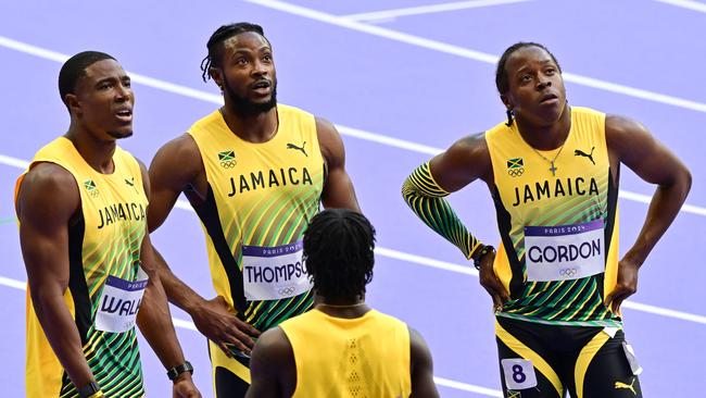 Jamaica's Jelani Walker, Kishane Thompson and Jehlani Gordon react after competing in the men's 4x100m relay. (Photo by Martin BERNETTI / AFP)