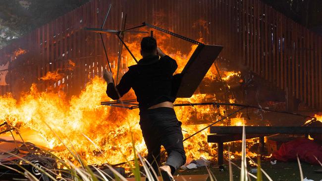 A man throws a desk onto a fire that rages on the grounds in front of Parliament in Wellington last year. Picture: AFP