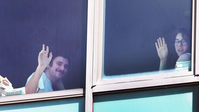 People in quarantine look out the windows of the Voco Hotel in Surfers Paradise, waiting for their exile to be over. Picture Glenn Hampson.