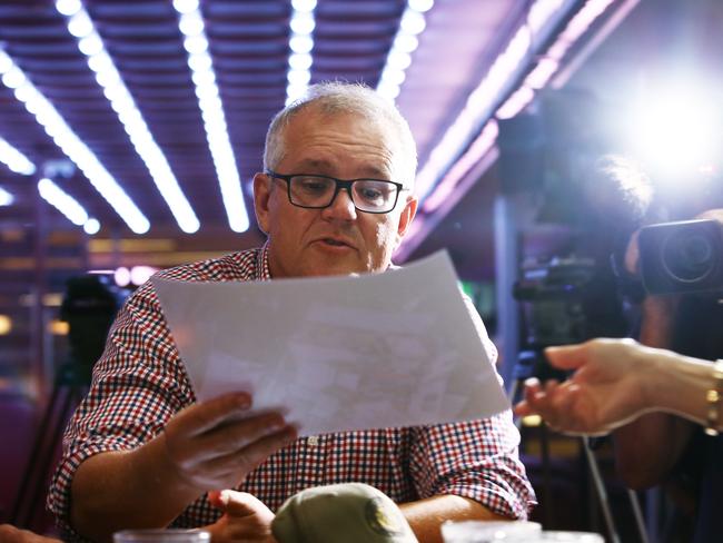 Prime Minister Scott Morrison looks over details of the Federal Government's $10 billion guarantee for a Northern Australia reinsurance pool in Cairns. Picture: Brendan Radke