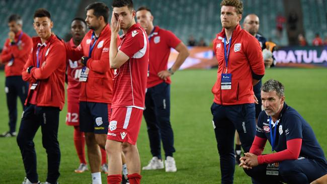 Adelaide head coach Marco Kurz, right, sits with his players as they watch the trophy presentation after going down to Sydney FC in extra time of the FFA Cup final. Picture: AAP Image/David Moir