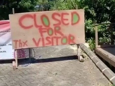 The tourists moved the sign despite the site being closed to visitors.