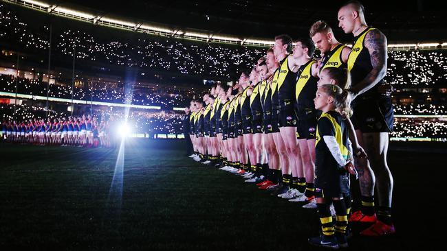 Players from Richmond and Melbourne observe a minute’s silence before the Anzac Eve AFL match last night to remember Diggers killed in battle. Picture: Getty Images