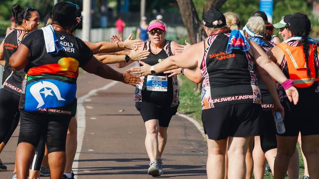 Tash Guse (centre) feels the love from The Darwin Deadly Runners as she approaches the finish line in the Santos City2Surf. Picture GLENN CAMPBELL