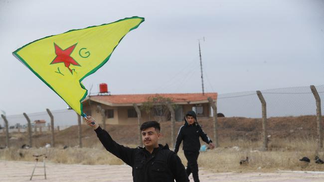 A Syrian Kurd waves the flag of YPG (People's Protection Units) near Qamishli's airport in northeastern Syria on December 8, following the fall of the capital Damascus to anti-government fighters. Picture: AFP