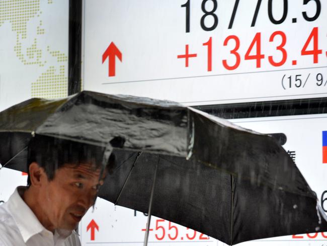 A pedestrian walks past a share prices board showing the closing numbers for the Nikkei-225 on the Tokyo Stock Exchange in Tokyo on September 9, 2015. Japan's share prices jumped 1,343.43 to close at 18,770.51 points at the Tokyo Stock Exchange, leading an Asian equities rally in its biggest one-day jump since late 2008 during the global financial crisis when markets were hit by wild volatility. AFP PHOTO / Yoshikazu TSUNO