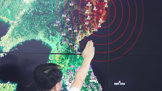 A South Korean official points to a map showing the seismic waves in North Korea, at the Korea Meteorological Administration in Seoul. Picture: AFP.