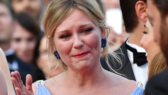 Kirsten Dunst cries as she walks the Cannes red carpet.