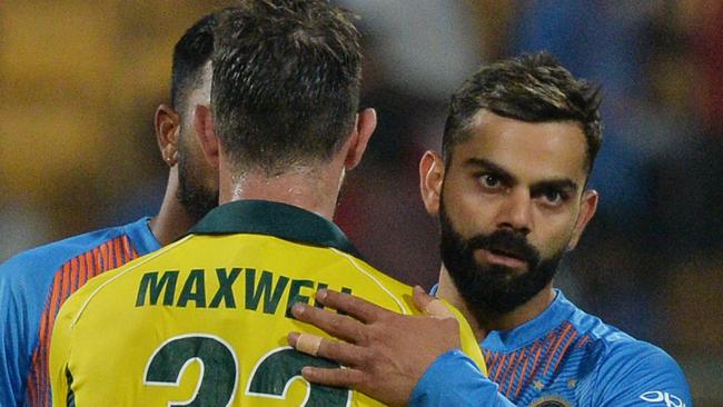 Glenn Maxwell and Virat Kohli embrace at the end of the match. (Photo by Manjunath KIRAN / AFP) / 