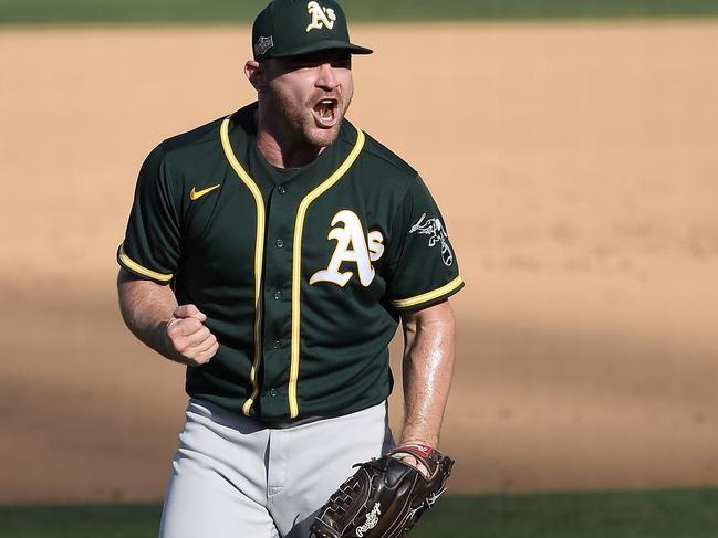 LOS ANGELES, CALIFORNIA - OCTOBER 07: Liam Hendriks #16 of the Oakland Athletics celebrates a 9-7 win against the Houston Astros in Game Three of the American League Division Series at Dodger Stadium on October 07, 2020 in Los Angeles, California.   Kevork Djansezian/Getty Images/AFP == FOR NEWSPAPERS, INTERNET, TELCOS & TELEVISION USE ONLY ==