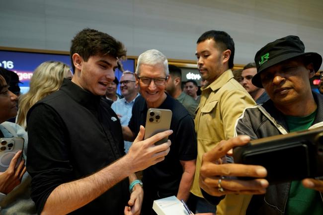 Apple CEO Tim Cook (C) is pushing the company into the AI era