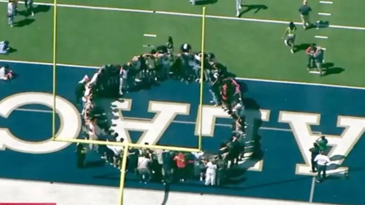 Students huddle together on football field after the shooting. Picture: ABC News.