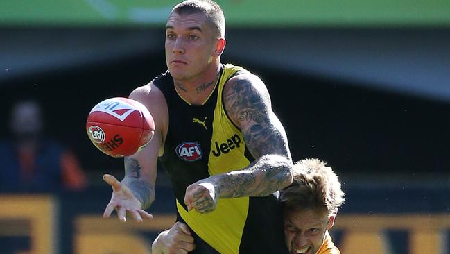 Dustin Martin is tackled by Sam Mitchell at the MCG. Picture: George Salpigtidis