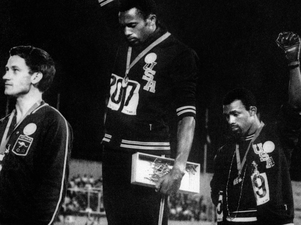 Peter Norman next to US athletes Tommie Smith (C) and John Carlos (R) raise their gloved fists in the Black Power salute to express their opposition to racism in the USA. Picture: EPU / AFP)