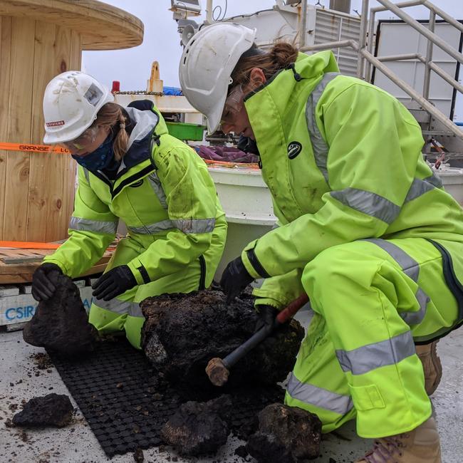 RV Investigator Voyage Manager Margot Hind (left) sorting samples on the back deck of the ship, processing rock samples from a dredge. Picture: Supplied