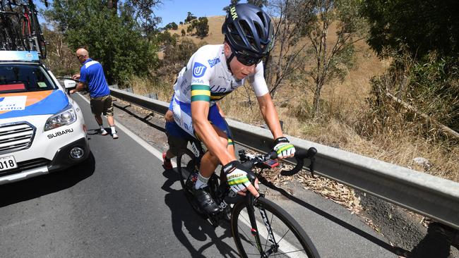 Australian rider Scott Bowden of team UniSA gets back on his bike after a wheel change during stage two of the Tour Down Under from Unley to Stirling, South Australia, Wednesday, January 17, 2018. (AAP Image/Dan Peled)