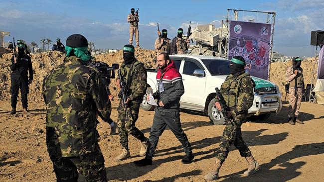 Al-Qassam Brigades, the armed wing of Hamas, hands over two of three Israeli hostages in Khan Younis in southern Gaza to the Red Cross on Saturday. Picture: Anadolu via Getty Images