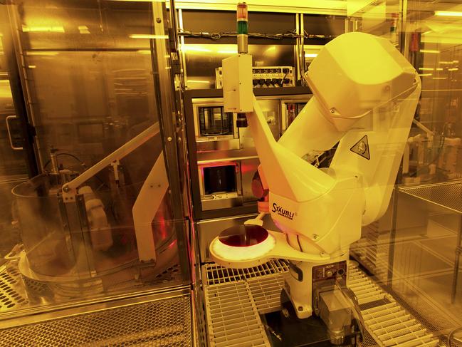 A robotic arm is used to produce a silicon wafer in a specially-lit clean room at the Texas Instruments semiconductor fabrication plant in Dallas, Texas. Picture: Bloomberg News