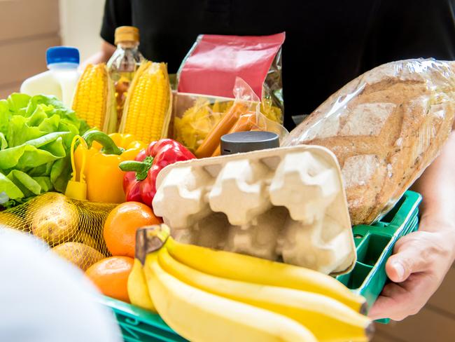 Delivery man in black uniform delivering food to customer at home - online grocery shopping service concept.  Picture: iStock.