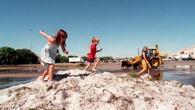 Sarah and Nicholas Goddard of Albany Creek play on the snowfields of ice in the car park after a hailstorm at Chermside shopping centre in April 1997.