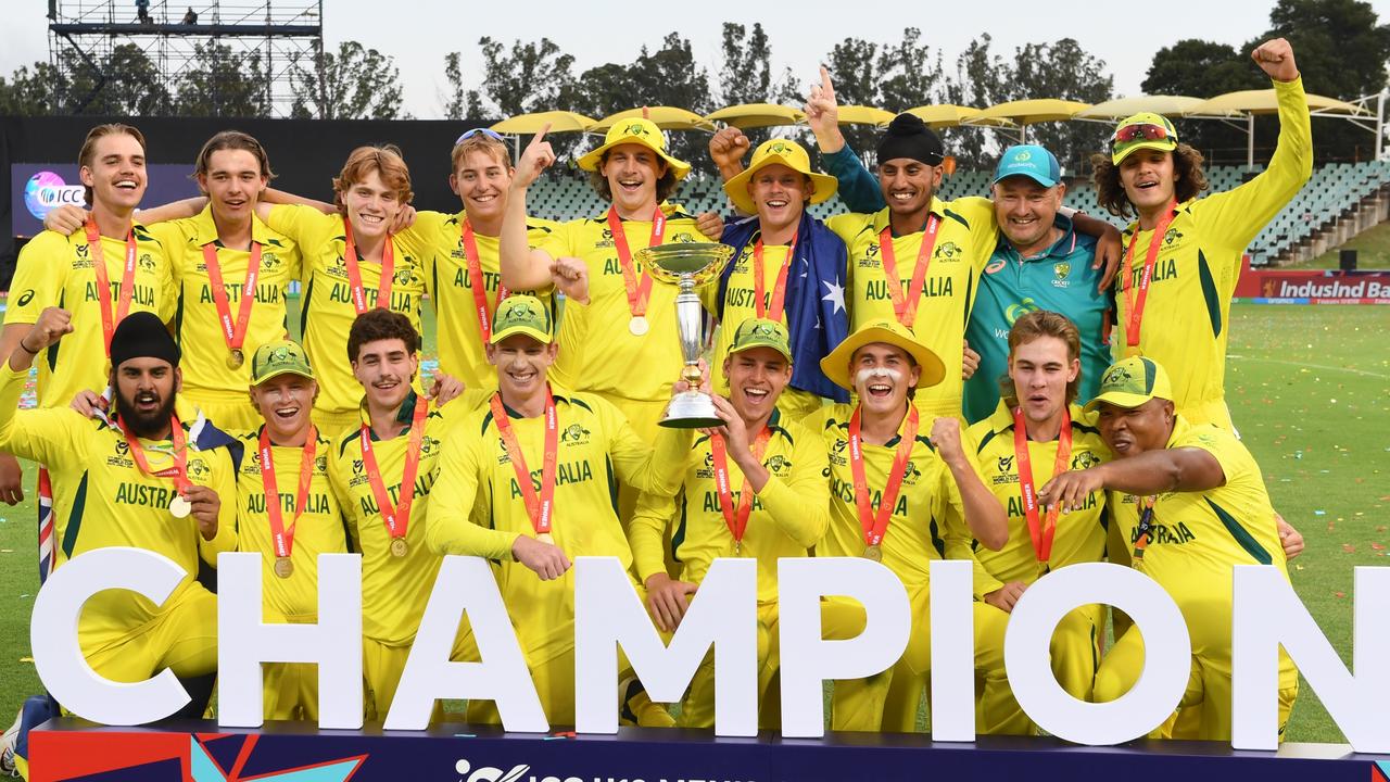 Australian Captain Hugh Weibgen and Harry Dixon lift the ICC U19 Men’s Cricket World Cup trophy as players celebrate after defeating India during the ICC U19 Men's Cricket World Cup in Benoni, South Africa. Picture: Lee Warren/Gallo Images/Getty Images